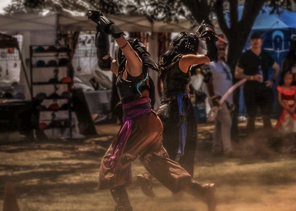Costumed performer sword fighting during a Renaissance-inspired performance at the West Texas Renaissance Festival in Odessa, Texas.